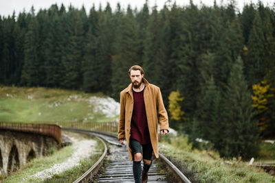 Portrait of man standing on railroad track