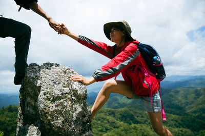 Low angle view of man climbing on rock