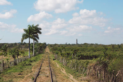 Panoramic view of railroad tracks on field against sky