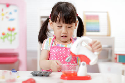 Cute girl playing with toy at home