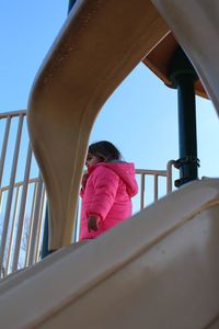 Low angle view of girl on slide in park