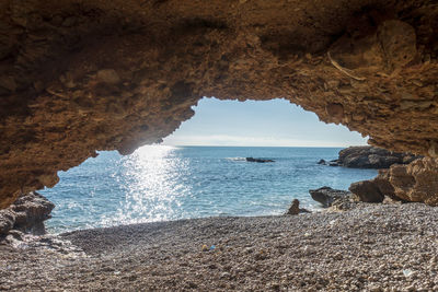 Scenic view of sea seen through cave