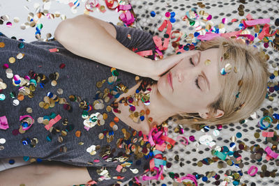 High angle view of woman relaxing with multi colored decorations on bed