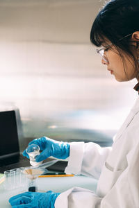 Young chemist doing experiment in laboratory