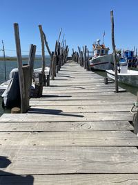 Wooden pier on sea against clear sky