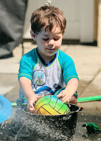 Siblings playing near a water basin in the back yard