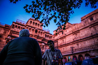 Men in city against sky at night