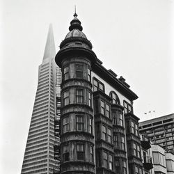 Low angle view of columbus tower with transamerica pyramid against clear sky