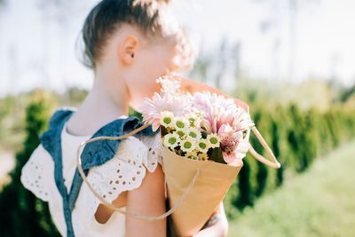 Midsection of girl holding flower bouquet