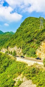 Cars on road by green mountains