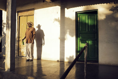 Man looking away while standing at porch