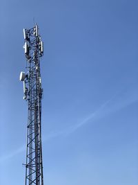 Low angle view of communications tower against blue sky