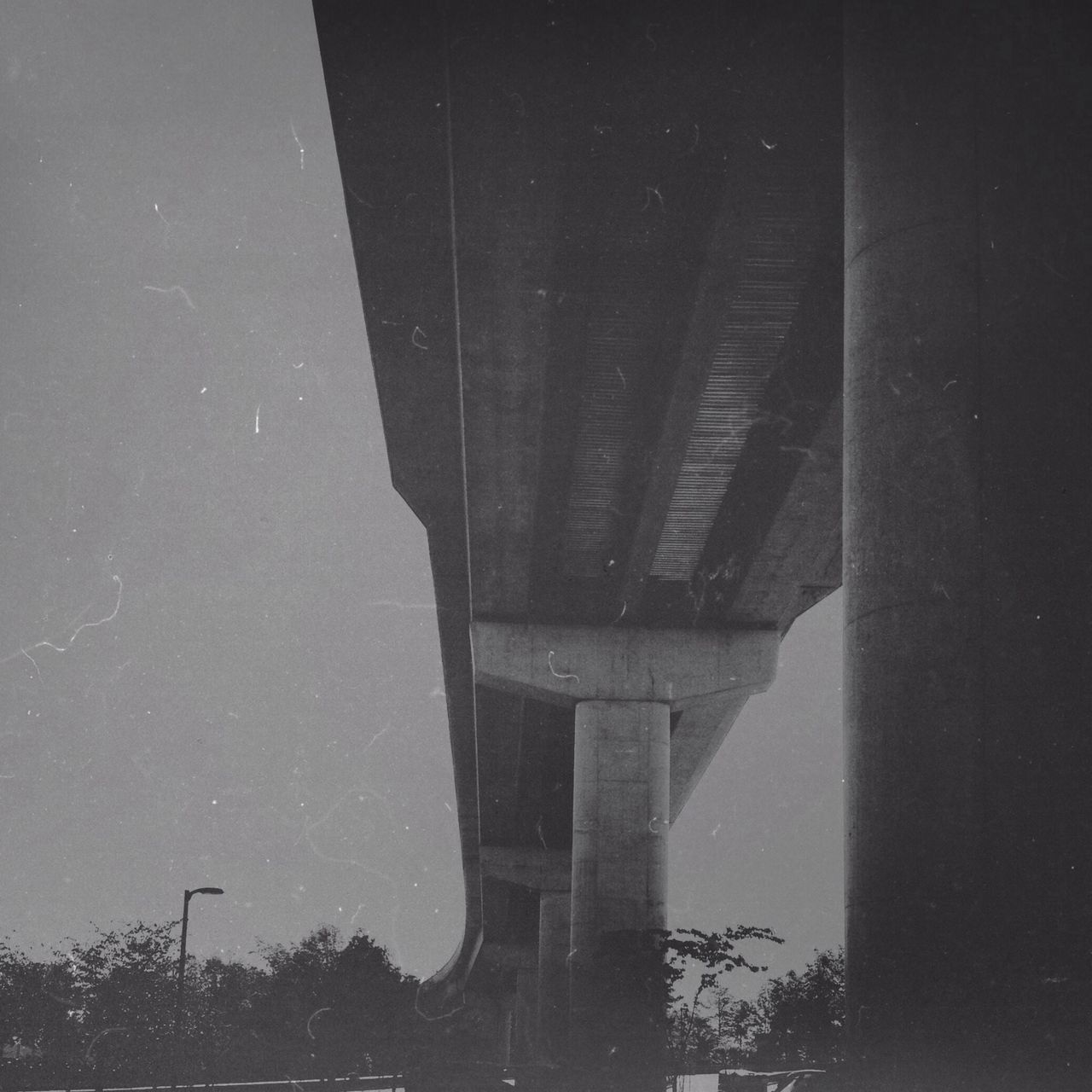 low angle view, connection, built structure, architecture, bridge - man made structure, transportation, sky, engineering, bridge, no people, outdoors, clear sky, day, architectural column, building exterior, reflection, tree, silhouette, dusk, nature