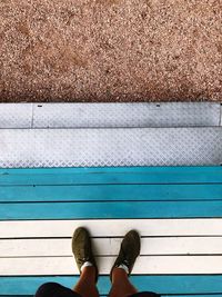 Low section of man standing on wood