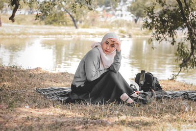 Portrait of young woman sitting on field