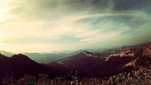 Scenic view of mountains against cloudy sky