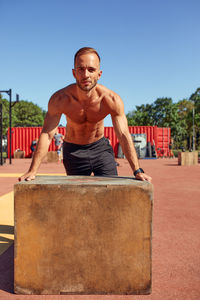 Side view of man sitting on field