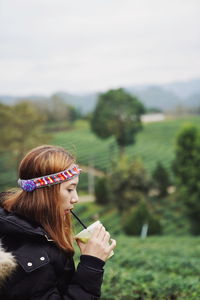Woman with arms raised on field