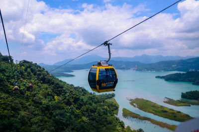 Overhead cable cars over mountains against sky