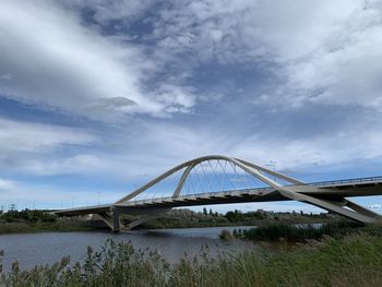 Arch bridge over river against sky