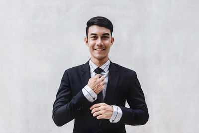 Portrait of young man wearing mask against white background