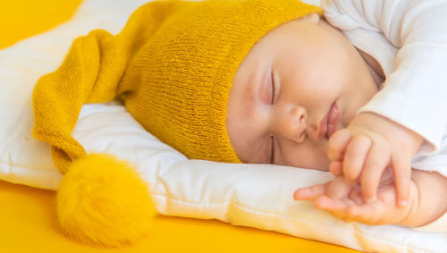 Close-up of baby girl sleeping on bed at home