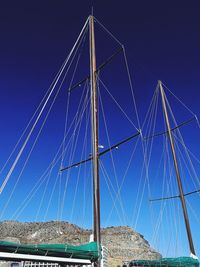 Low angle view of sailboat against clear blue sky