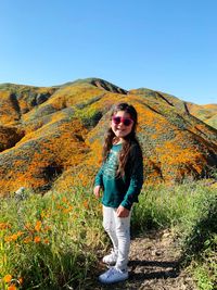 Portrait of beautiful woman standing on land against sky