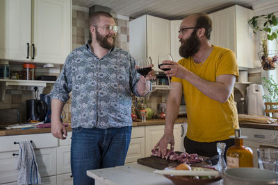 Men in kitchen having wine