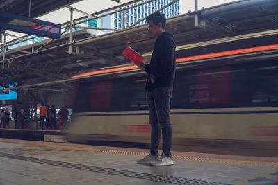 Full length of man standing at railroad station