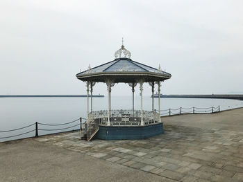 Lifeguard hut on sea against sky