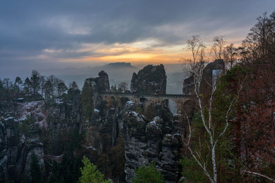 View of rock formations against cloudy sky during sunset