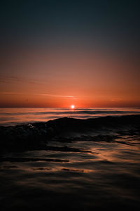 Scenic view of sea against romantic sky at sunset