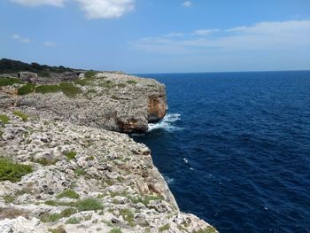 Scenic view of rocks in sea against sky