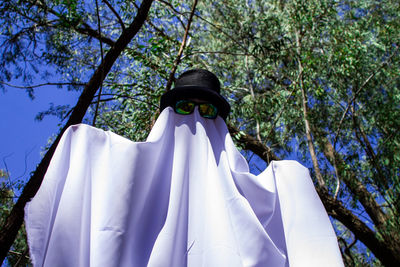 Low angle view of clothes hanging on tree against sky