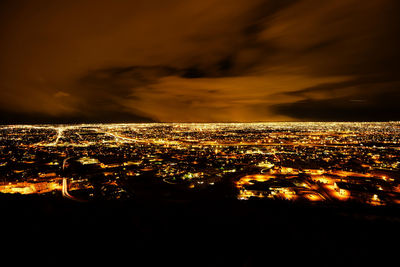 High angle view of illuminated buildings against sky at night