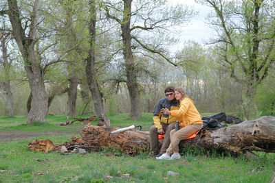 Side view of woman sitting on field