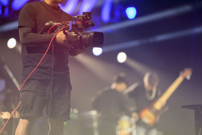 Midsection of mid adult man photographing through camera