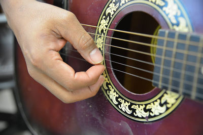 Cropped hand playing guitar