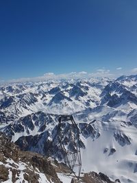 Aerial view of snowcapped mountains against clear blue sky