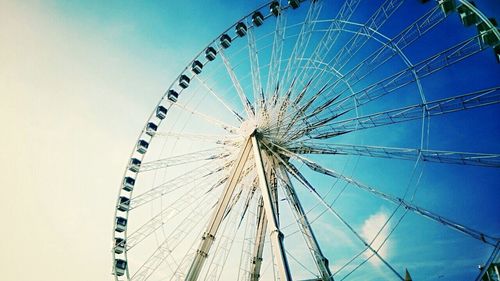 Low angle view of ferris wheel against blue sky