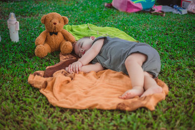 Cute baby boy sleeping on blanket in park