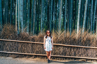 Portrait of woman standing on footpath in forest