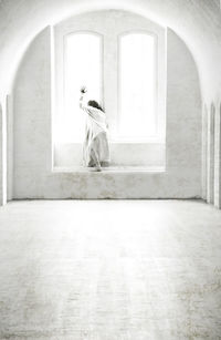 Rear view of woman walking in corridor of building