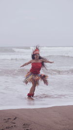 Rear view of woman standing at beach