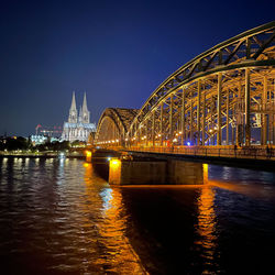 Cologne cathedral and hohenzollern bridge at night.