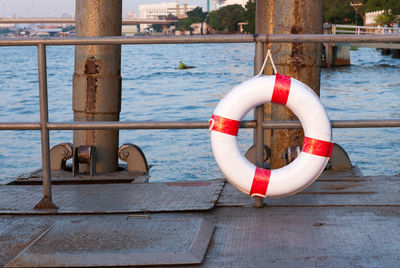 Life belt hanging on railing against river