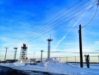 Electricity pylon on snow covered landscape