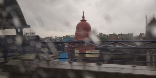 Buildings in city against cloudy sky