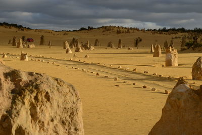 Panoramic view of people in desert against sky